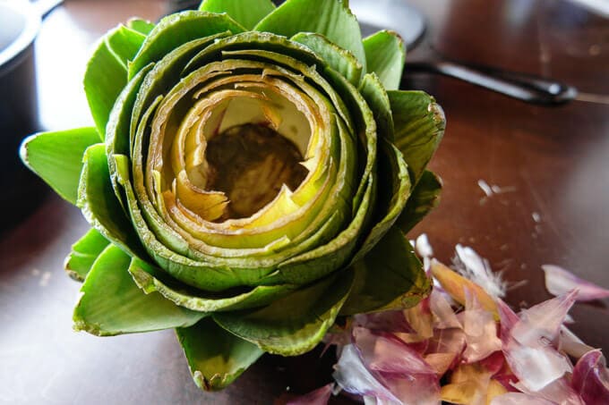 How to make easy Italian oven-roasted artichokes with three ingredients. Just pour some premade sauce over and cook. The flavors will seep in and the result is WAY better than boiling.