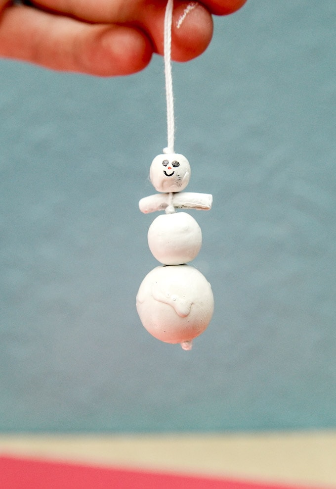 Melting snowman ornament craft made with macaroni, beads and paint