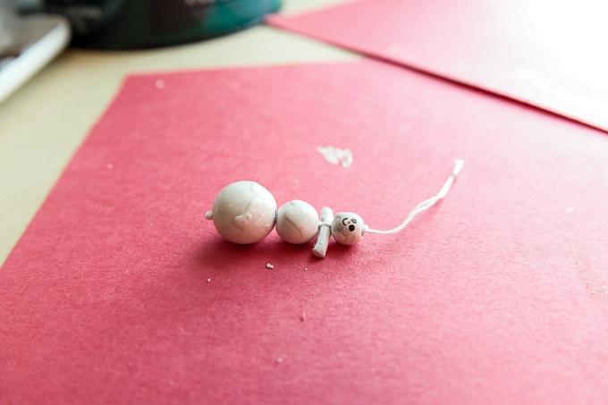 Melting snowman ornament craft made with macaroni, beads and paint